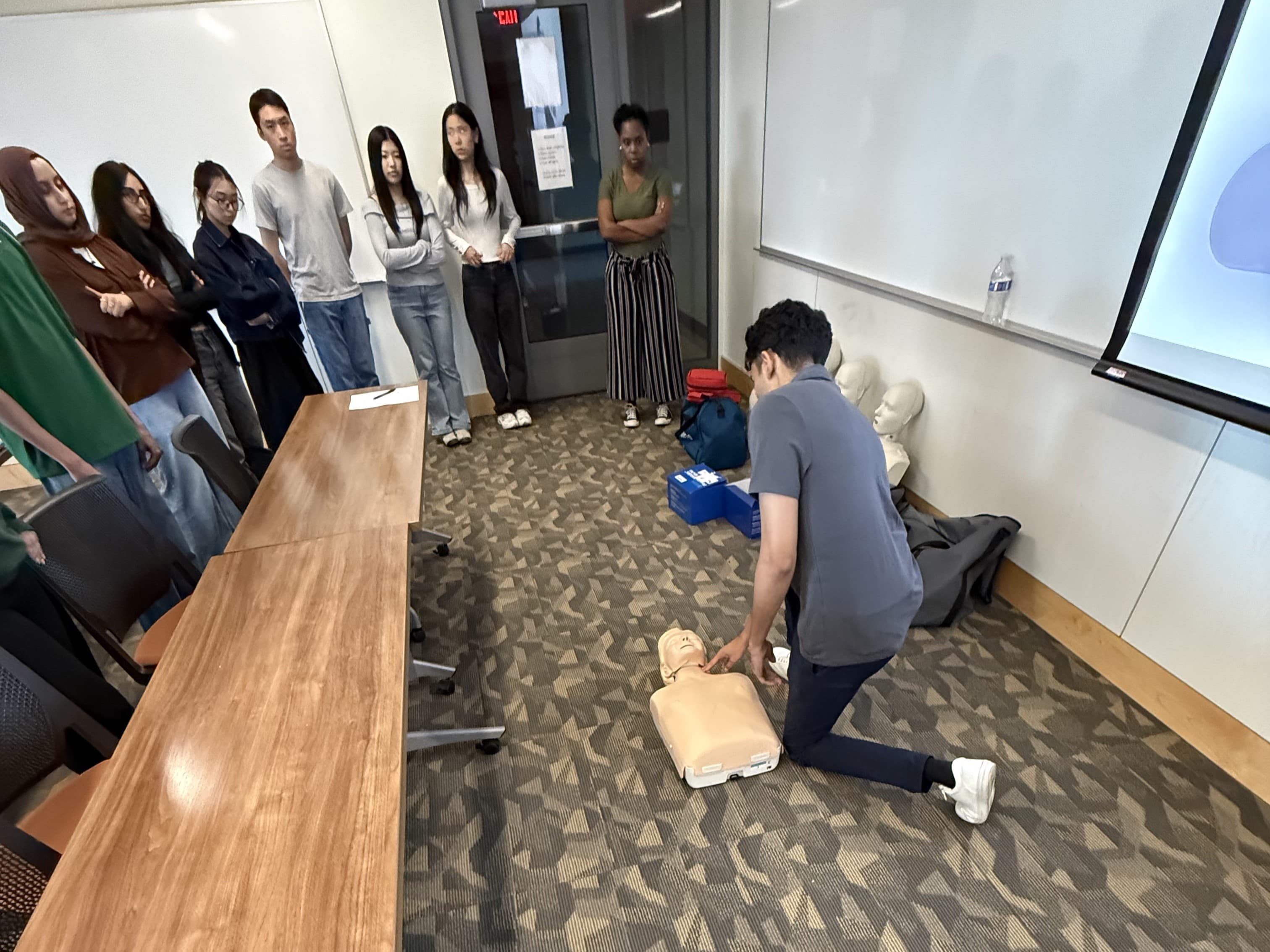 Instructor demonstrating CPR technique on a manikin
